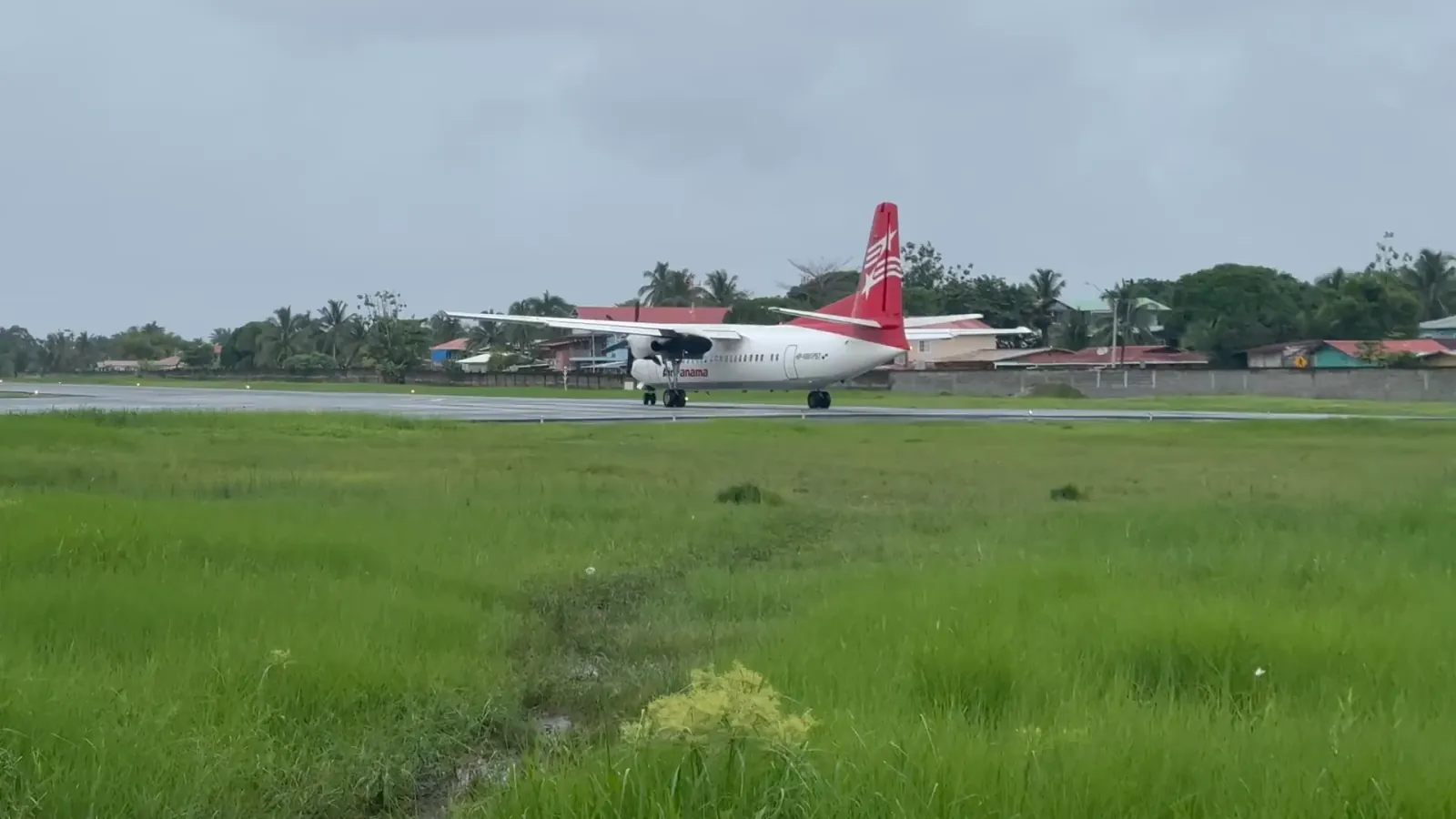 The red Air Panama turboprop taxiing on the Bocas del Toro airstrip