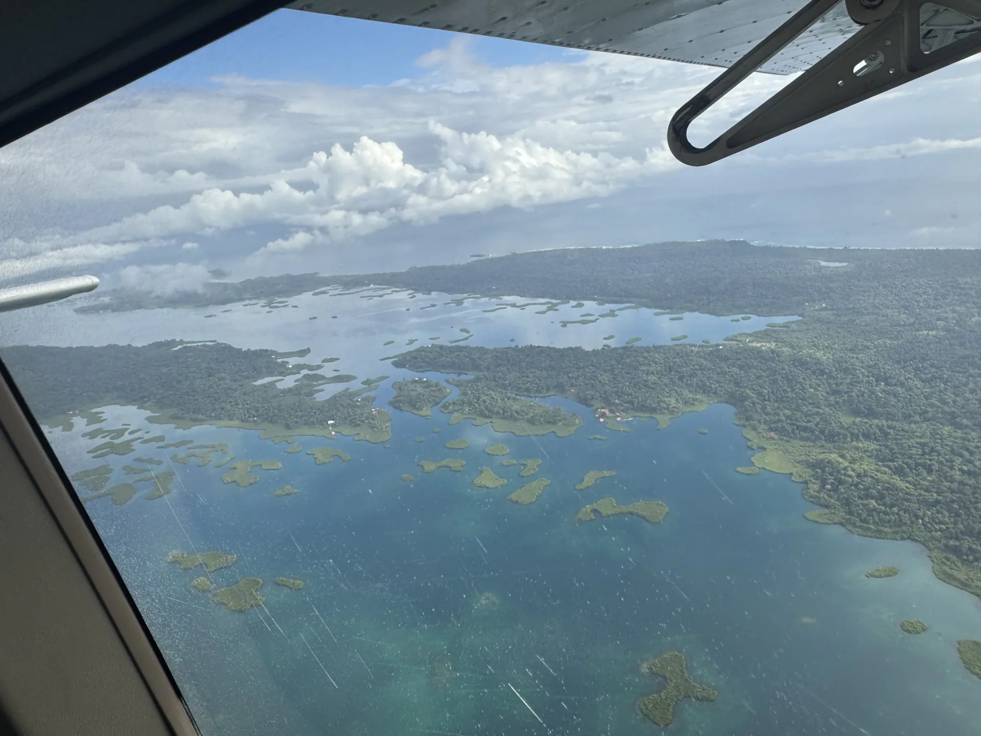 The archipelago seen through a small plane window, with the wing strut in view